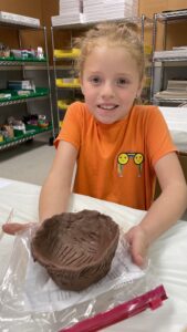 A little girl and a clay pot